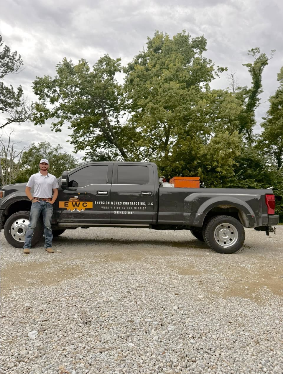 Colton, owner of Envision Works Contracting LLC, beside his branded company truck