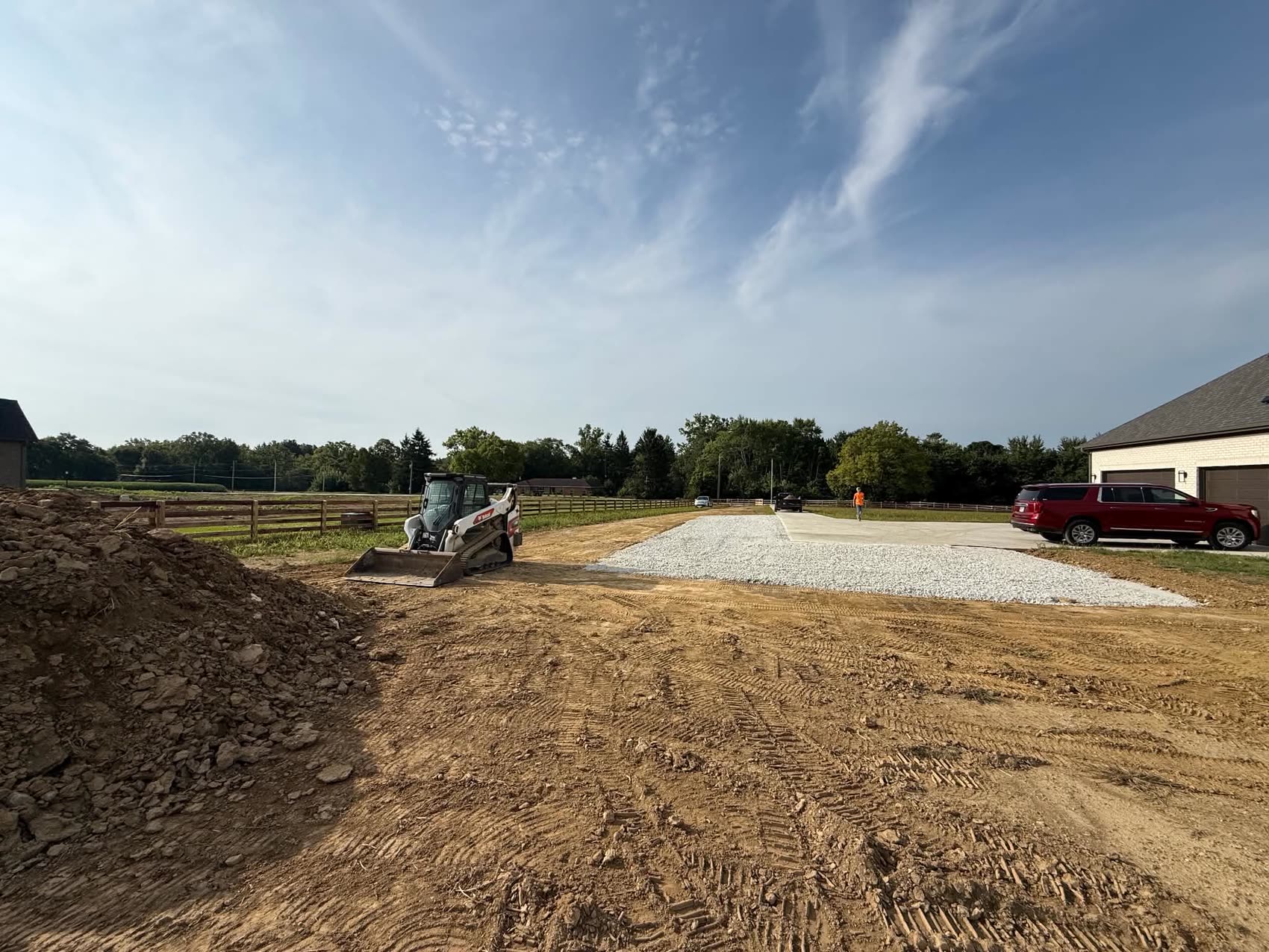 A skid steer shaping dirt around a newly built house