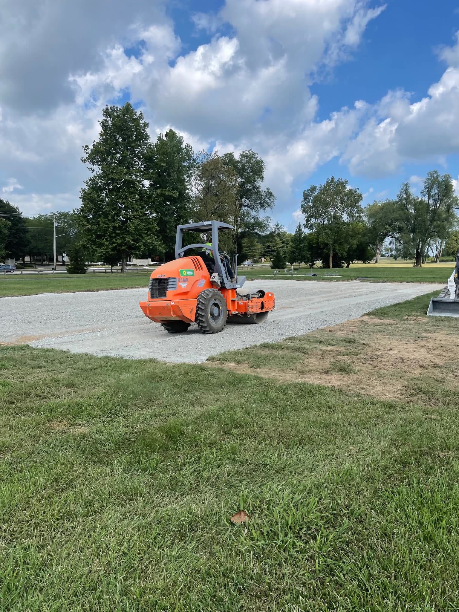 A ride-on roller compacting a new gravel pad